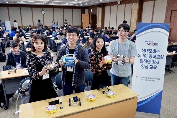 현대모비스 직원 주니어공학교실 강사들이 한국공학한림원과 한양대 청소년 과학기술진흥센터 소속 강사진들의 설명을 들으며 만든 어린이 과학 키트를 들어보이고 있다.