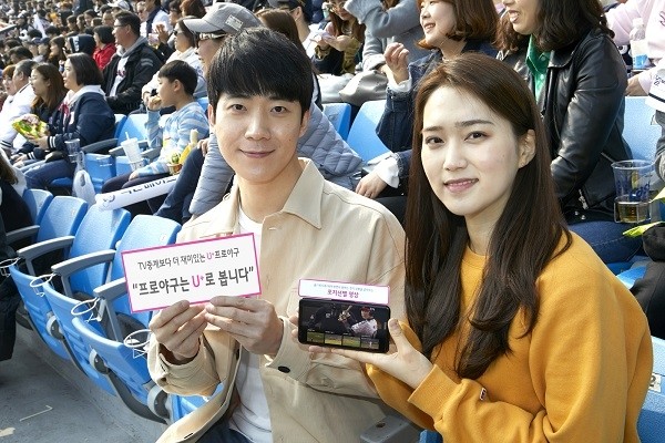 LG유플러스는 프로야구 개막일에 맞춰 새롭게 선보인 ‘U+프로야구’ 서비스 이용자가 개막 직후인 24일(토), 25일(일) 이틀간 10만명을 돌파했다고 밝혔다. 잠실야구장을 찾은 LG유플러스 고객이 스마트폰에서 U+프로야구 서비스를 이용해 야구경기를 관람하고 있는 모습.