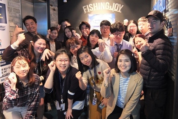 뉴딘파스텔 직업장애인합창단 단원과 골프존뉴딘홀딩스 임직원이 장애인의 날을 맞이해 서울 송파구 스크린낚시장 피싱조이에서 레저 행사를 진행했으며, 진행에 앞서 단체사진을 촬영하고 있다.