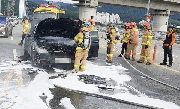 30일 오후 대전 유성구의 한 도로를 달리던 BMW 750i 승용차에서 불이나 출동한 119소방대원들이 화재를 진화한 뒤 차량을 살펴보고 있다. 화재가 난 BMW 750i 승용차는 휘발유 차량으로 리콜 대상이 아니다. (사진=newsis)