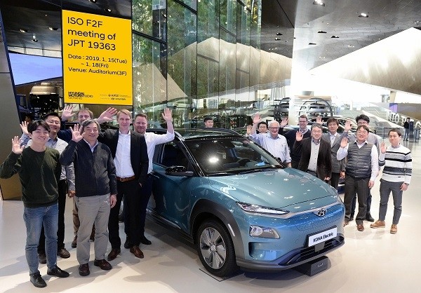 현대모터스튜디오 고양에서 열린 ISO 전기차 무선충전 국제표준화 회의에 참가한 전문가들이 코나EV와 함께 기념 촬영을 하고 있다. [제공=현대차]