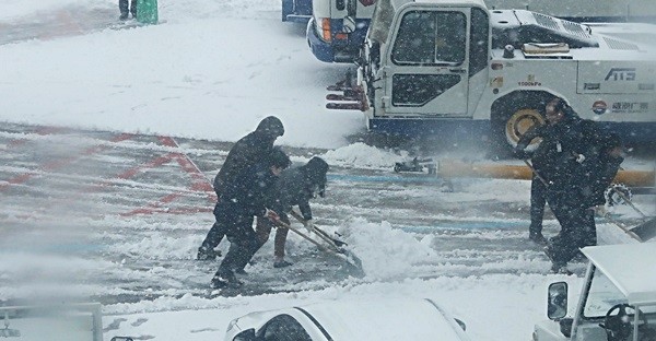 올들어 제주 지역에 최강 한파가 몰아친 11일 오전 제주국제공항 활주로에 눈이 쌓여 직원들이 제설작업을 하고 있다.