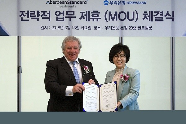 우리은행은 지난 13일 서울 중구 본점에서 ‘우리은행-英 애버딘 스탠다드 인베스트먼츠와 전략적 업무제휴 협약’을 체결했다. 정종숙 우리은행 WM그룹장(사진 오른쪽)이 마틴 길버트 애버딘 스탠다드 인베스트먼츠 CEO와 기념촬영을 하고 있다.